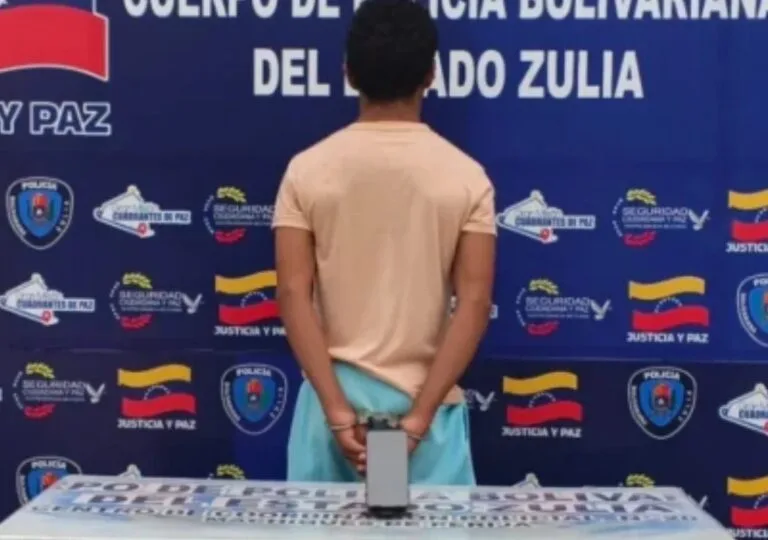 Un detenido de espaldas y esposado ante el panel del Cpbez en Machiques de Perijá, en el caso de abuso sexual en Machiques