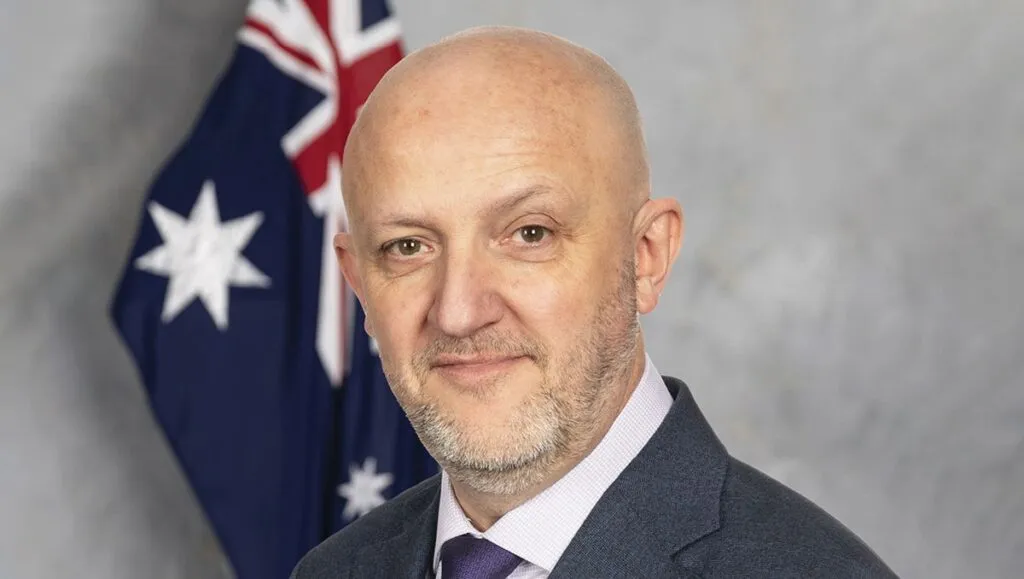 Amenaza de la IA: Mike Burgess, director general de la ASIO, en un retrato oficial junto a la bandera de Australia