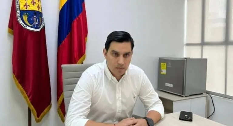 Miguel Castellanos, exsecretario de Gobierno de Cúcuta asesinado, sentado en su despacho con las banderas de Cúcuta y de Colombia detrás