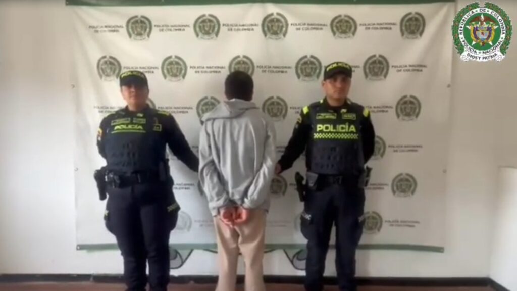 Ataque con arma blanca en Chiquinquirá: el presunto agresor capturado, de espaldas y esposado, entre dos policías nacionales