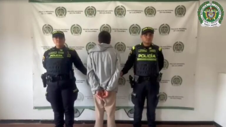 Ataque con arma blanca en Chiquinquirá: el presunto agresor capturado, de espaldas y esposado, entre dos policías nacionales