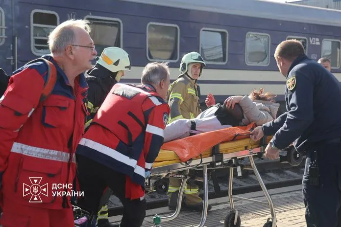 Ataque en Dnipró: rescatistas del Servicio Estatal de Emergencias de Ucrania evacuan en camilla a una persona herida junto al tren alcanzado en la estación