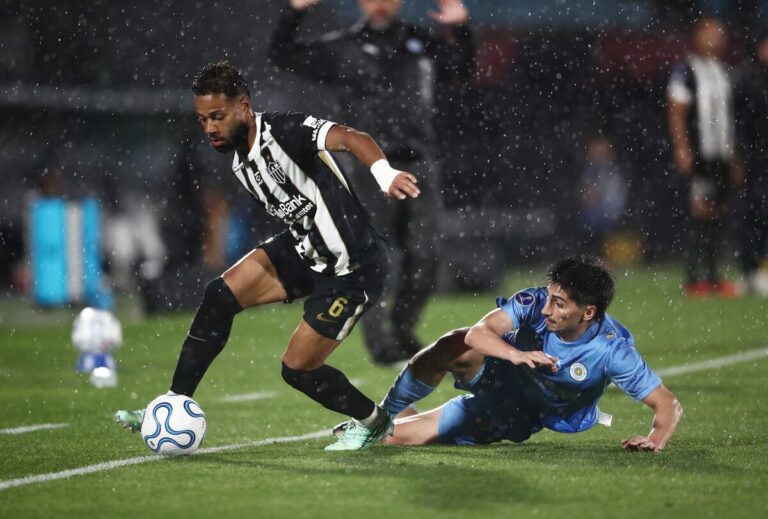 Atlético Mineiro a la final de la Sudamericana: un jugador del Galo protege el balón ante la barrida de un futbolista del Montevideo City Torque bajo la lluvia en el estadio Centenario