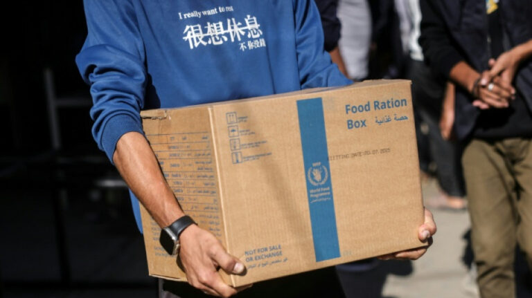 Persona cargando una caja de ración de alimentos de la ayuda del PMA en Gaza