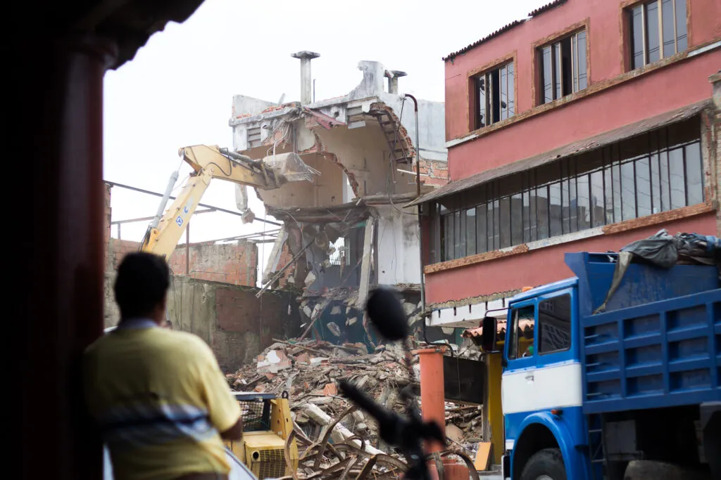 Una retroexcavadora retira los escombros de un edificio colapsado en El Junquito, mientras los vecinos siguen esperando la ayuda en El Junquito