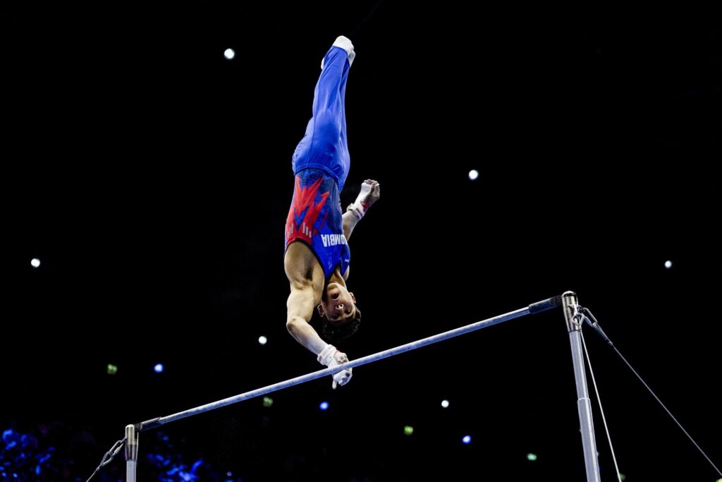 Barajas y Vera en Róterdam: un gimnasta colombiano en plena suelta sobre la barra fija del Mundial de gimnasia