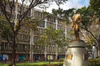 Becas universitarias Venezuela: campus de una universidad venezolana con su estatua y jardines