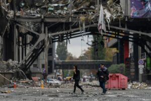 Bombardeos rusos en Ucrania: dos personas pasan frente a un centro comercial destrozado tras un ataque aéreo en Kiev