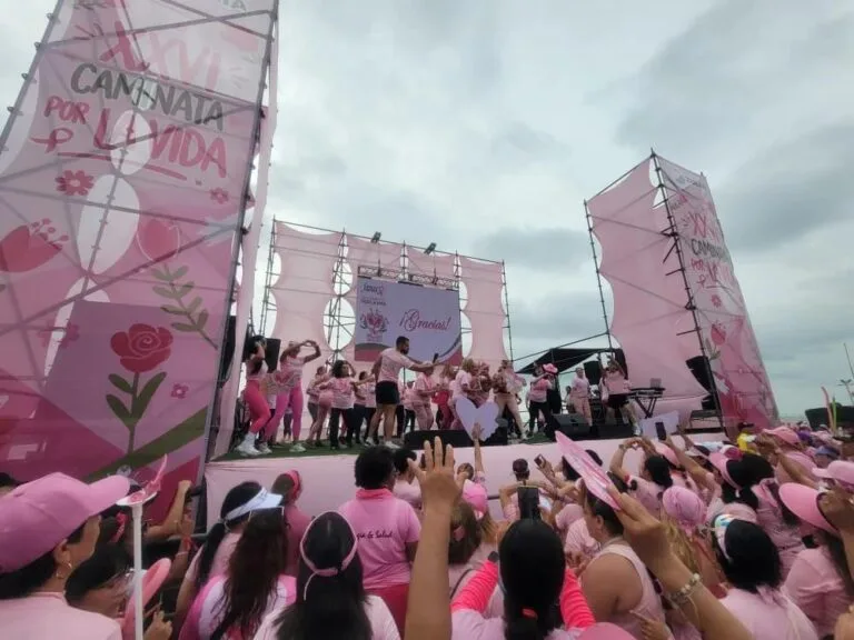 Participantes de rosa frente a la tarima de la Caminata por la Vida de FAMAC en Maracaibo, bajo el cartel de la edición XXVI de la marcha