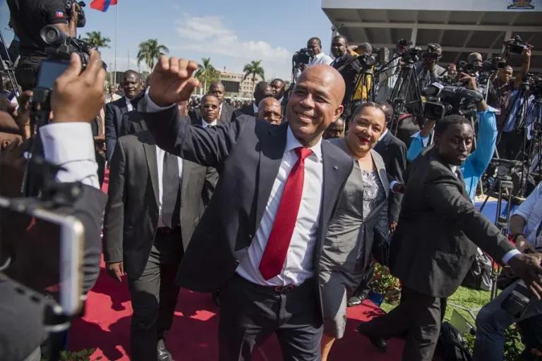 candidatura de Martelly: el expresidente de Haití saluda con corbata roja ante las cámaras