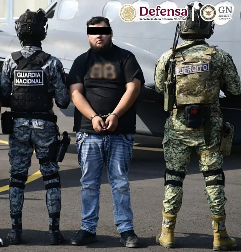 Detenido por la captura de Axel en Matamoros, esposado y custodiado por la Guardia Nacional y el Ejército junto a la aeronave del traslado
