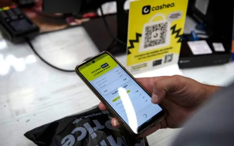 Cashea y Cantv: una persona paga en cuotas desde la aplicación de Cashea en su teléfono, junto a un mostrador de la plataforma