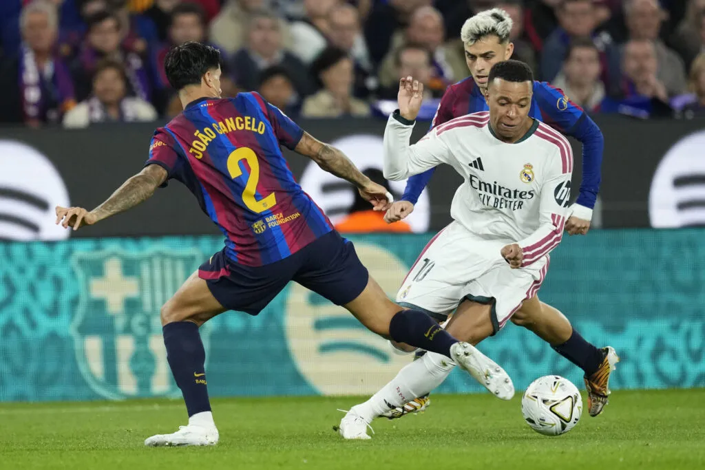 China suspende LaLiga: Kylian Mbappé, con la camiseta del Real Madrid, disputa el balón ante João Cancelo, del Barcelona, en un partido de la Liga española