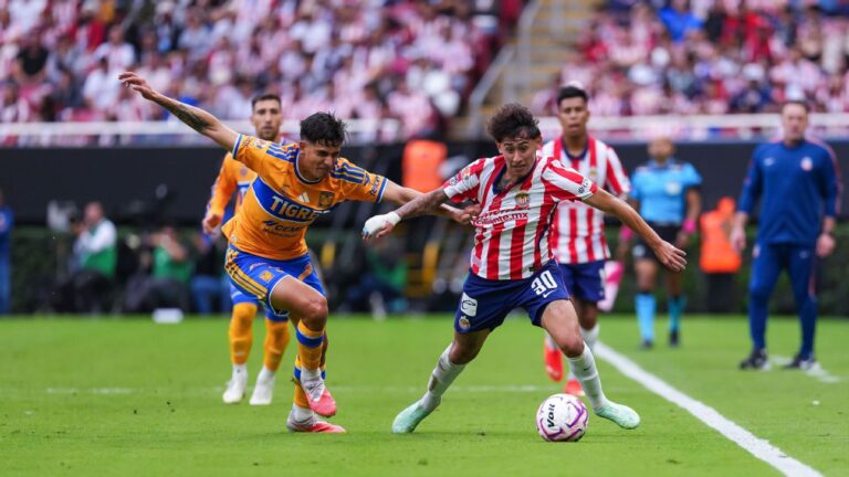 Chivas 1-1 Tigres: un jugador del Guadalajara disputa el balón con un futbolista de Tigres en el Estadio Akron