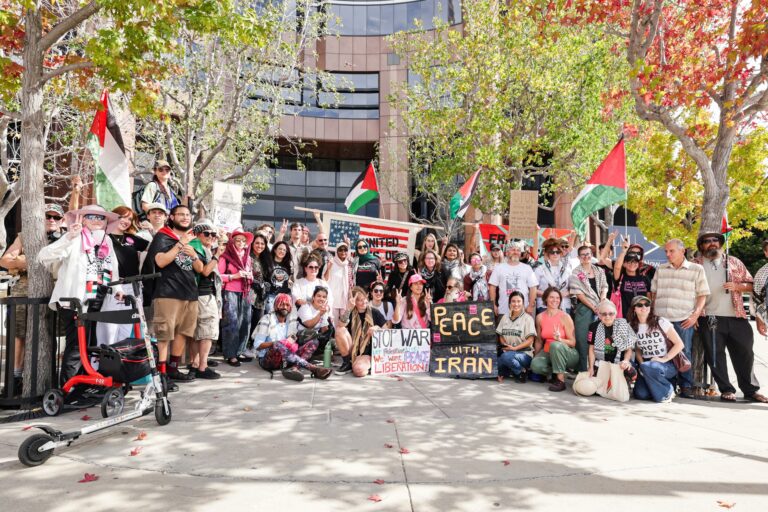 Participantes del convoy de la libertad posan con banderas palestinas y pancartas antes de salir de Los Ángeles rumbo a Washington