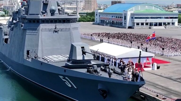 Corea del Norte ordena a sus tropas medidas contundentes: buque de guerra norcoreano en un puerto durante una ceremonia militar con la bandera de Corea del Norte