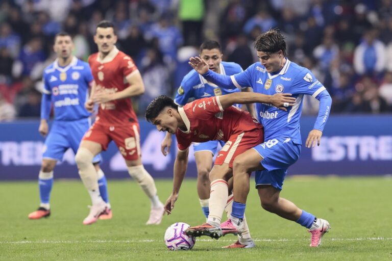Cruz Azul 5-0 Juárez: un jugador de La Máquina, de azul, disputa el balón con un futbolista del Juárez FC, de rojo, en el Coloso de Santa Úrsula