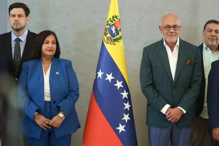 Dinorah Figuera y Jorge Rodríguez, jefes negociadores de la oposición y el chavismo en el diálogo en Venezuela, junto a la bandera nacional en Caracas