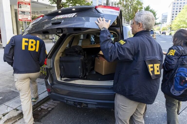 Demanda FBI Trump: agentes del FBI con chaquetas de la agencia junto a un vehículo durante un operativo en Estados Unidos