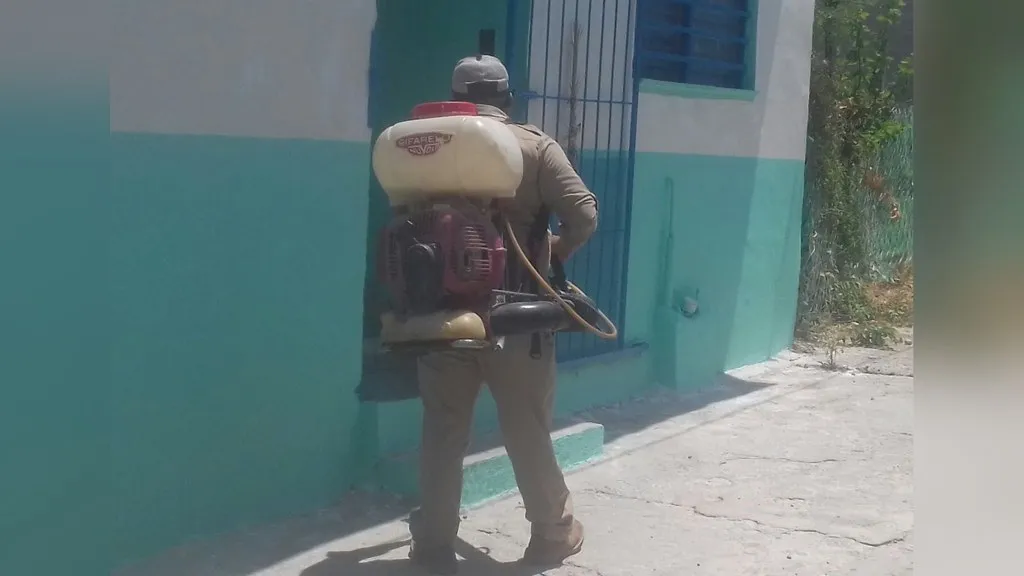 Fumigación contra el dengue en Machiques: un trabajador rocía una vivienda para combatir al mosquito transmisor
