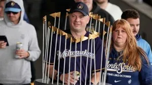 Desfile de los Cerveceros: un aficionado disfrazado del Trofeo del Comisionado llega al rally de Milwaukee