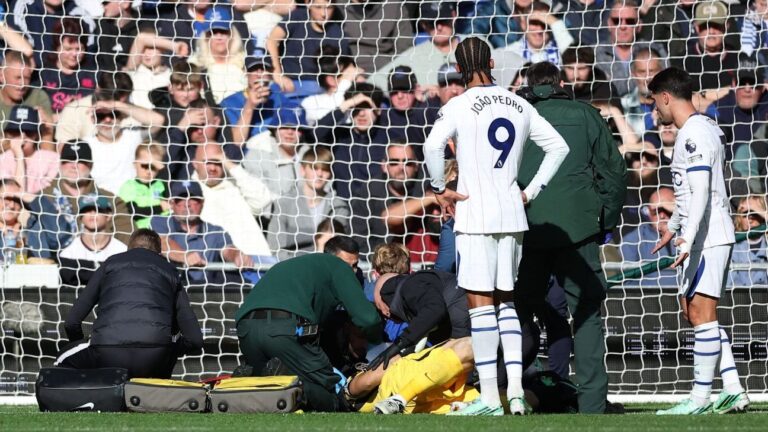 Dibu Martínez evacuado en camilla: el portero del Chelsea, tendido en el suelo en su área, atendido por los médicos ante João Pedro y Neto en el Everton-Chelsea