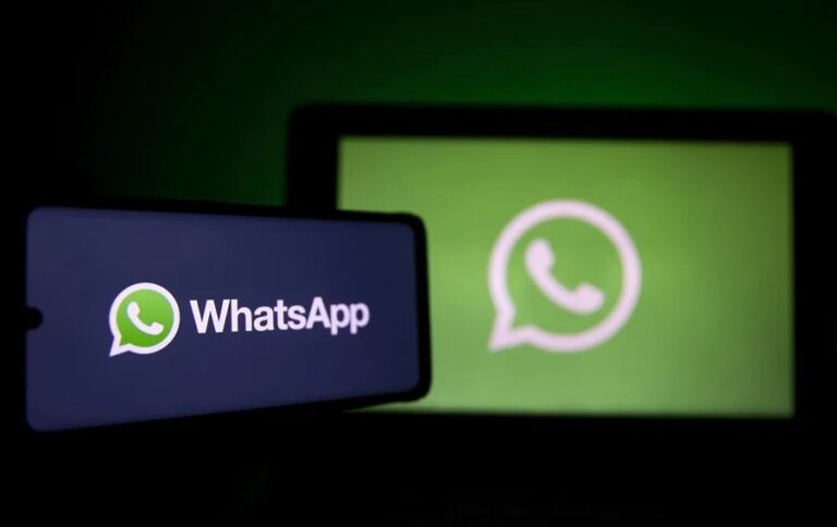 Un teléfono y una pantalla muestran el logotipo de WhatsApp en verde sobre fondo oscuro