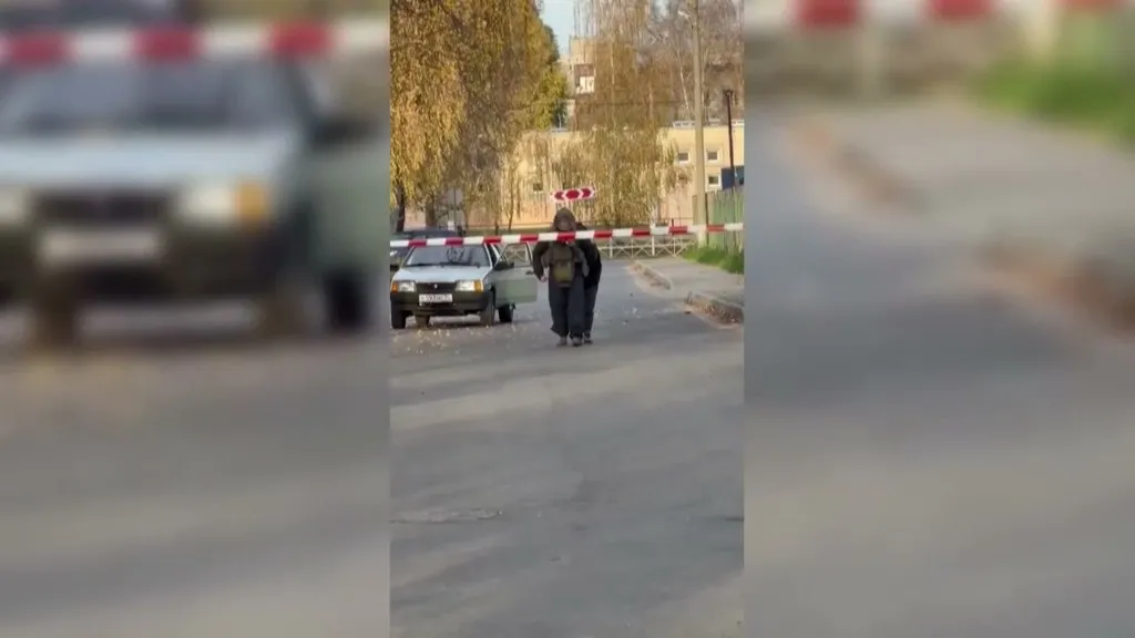 Explosivos en Briansk: un zapador con chaleco antibalas evacúa a una conductora de una calle acordonada de Bezhitski