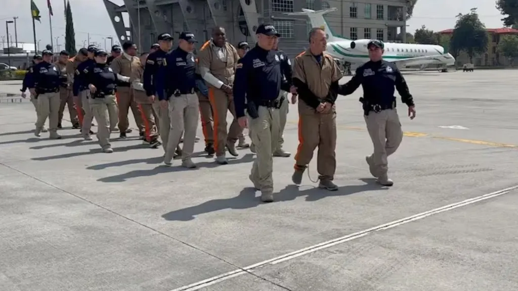 Operativo de extradición del Monstruo del Modelaje: agentes de la Policía de Colombia escoltan a los extraditados en la pista de un aeropuerto
