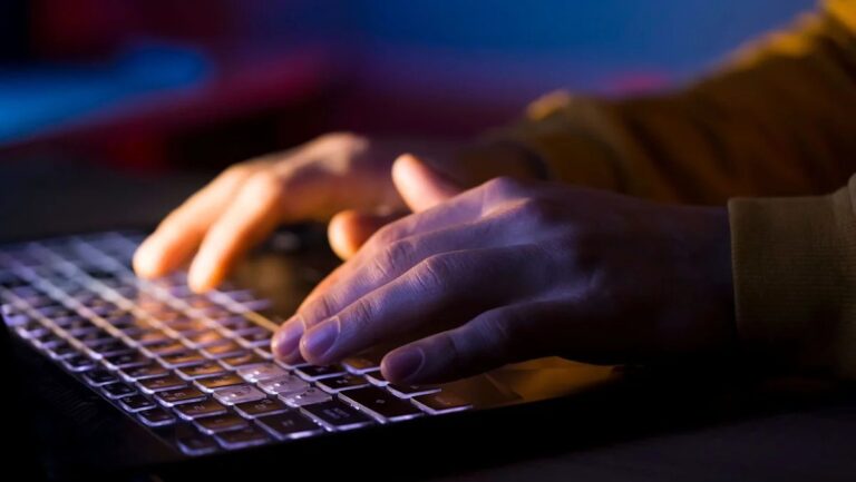 falla crítica en PHP: manos sobre el teclado de una laptop en la oscuridad