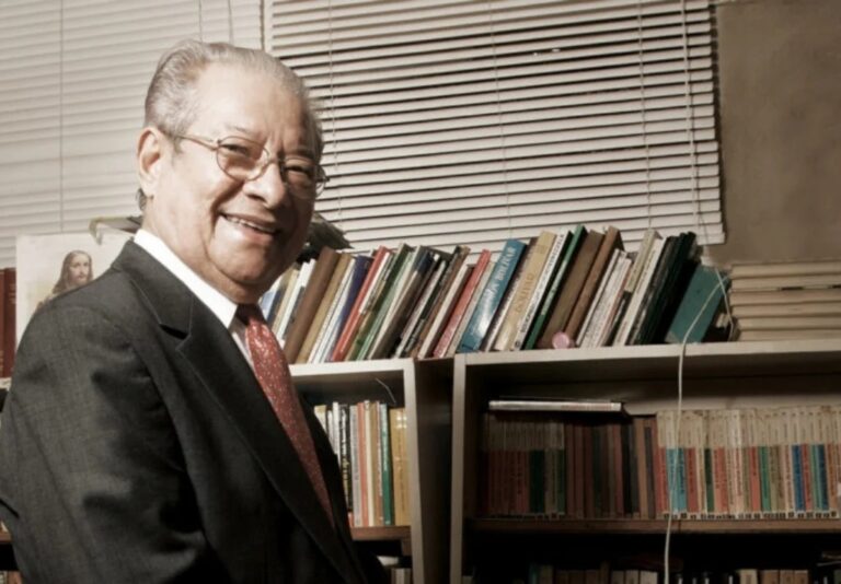 Tito Balza Santaella sonríe frente a los libros de su biblioteca, en una fotografía de archivo