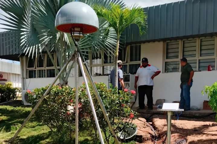 Estación geodésica Funvisis Caracas: antena satelital instalada sobre trípode en la sede del organismo con técnicos trabajando al fondo
