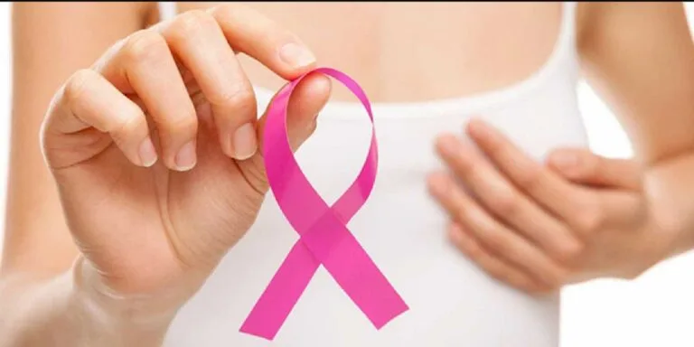 Cáncer mujeres venezolanas: mujer sostiene el lazo rosa de la lucha contra el cáncer de mama