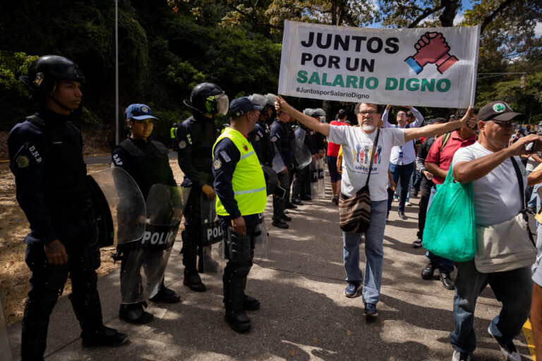 Trabajadores venezolanos con una pancarta por un salario digno durante una protesta en Caracas