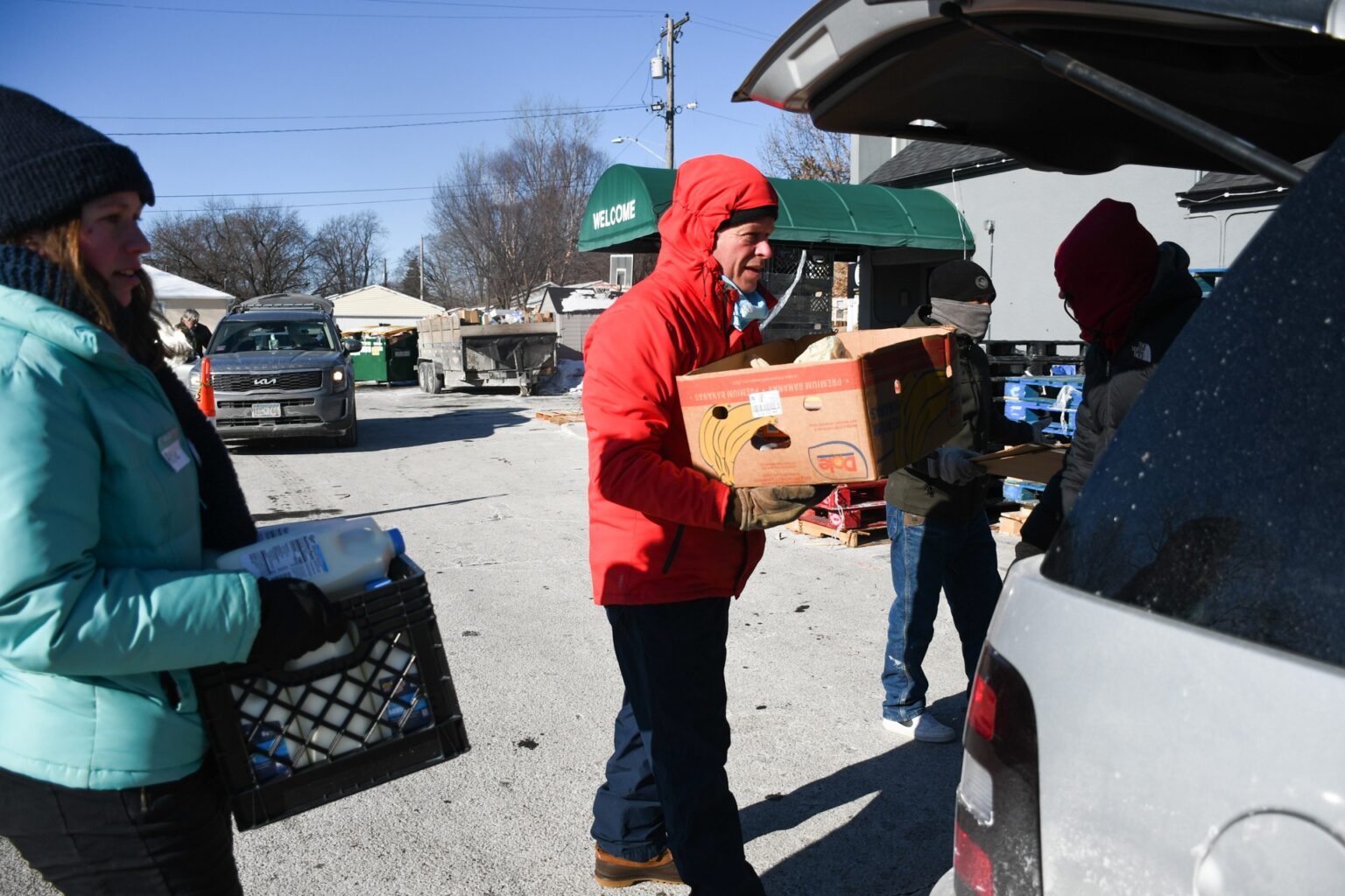 Voluntarios cargan cajas y leche en un banco de alimentos: la inseguridad alimentaria en Colorado crece entre inmigrantes y refugiados