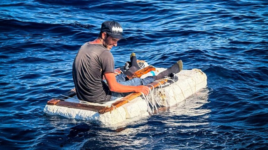 Migrante cubano sentado sobre una balsa improvisada de espuma y madera frente a la costa de Florida