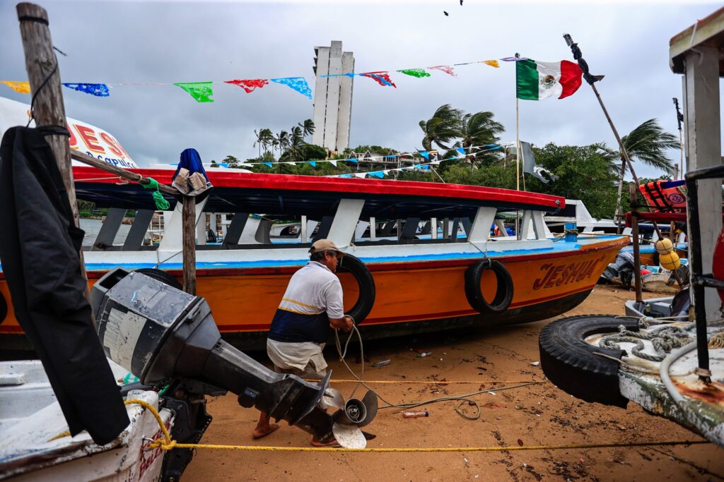 Huracán Trudy categoría 3: un pescador asegura su lancha en Acapulco ante la llegada del ciclón al Pacífico mexicano
