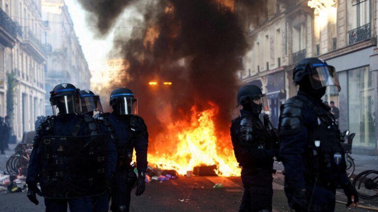 Policías antidisturbios de Francia frente a una barricada en llamas; Francia desplegará militares para reforzarlos en las protestas del sábado