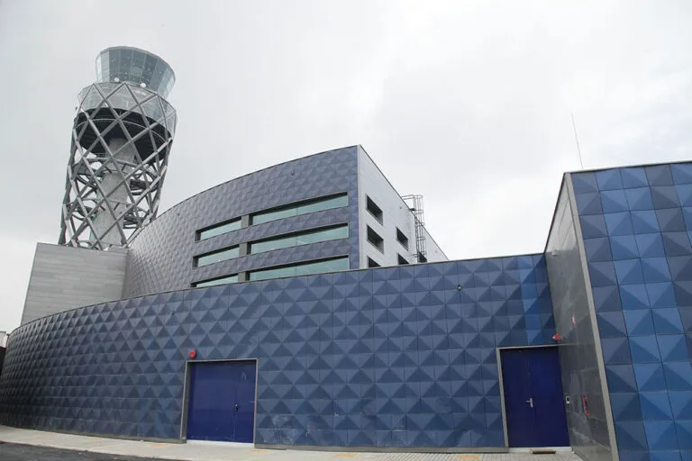 Funcionario de la Aerocivil murió en El Dorado: la torre de control del aeropuerto de Bogotá y el edificio azul del Centro de Gestión Aeronáutico de Colombia (CGAC)