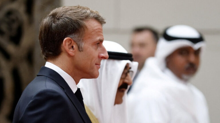 Gira de Macron por el Golfo: Emmanuel Macron, de perfil junto a dignatarios kuwaitíes con vestimenta tradicional, a su llegada a Kuwait este lunes