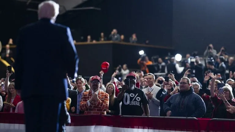 Gira final de Trump: el presidente, de espaldas, saluda a sus seguidores en un mitin de campaña en Iowa