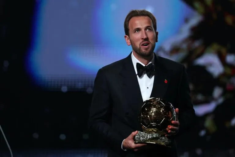Harry Kane gana el Balón de Oro 2026: el delantero inglés, de esmoquin, sostiene el trofeo dorado en la gala del London Palladium de Londres