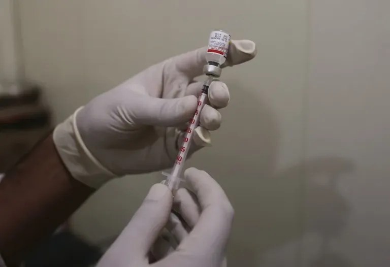 Inyectable de cadáveres: unas manos con guantes preparan una jeringa desde un vial durante un procedimiento