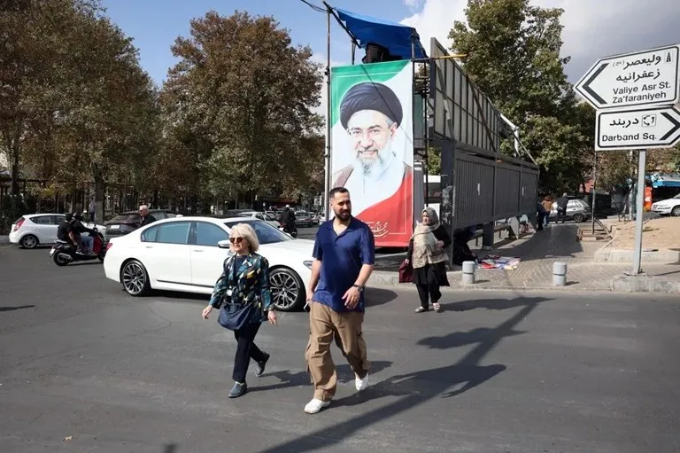 Irán relatora ONU: una calle de Teherán con peatones y un cartel oficial en una avenida de la capital iraní