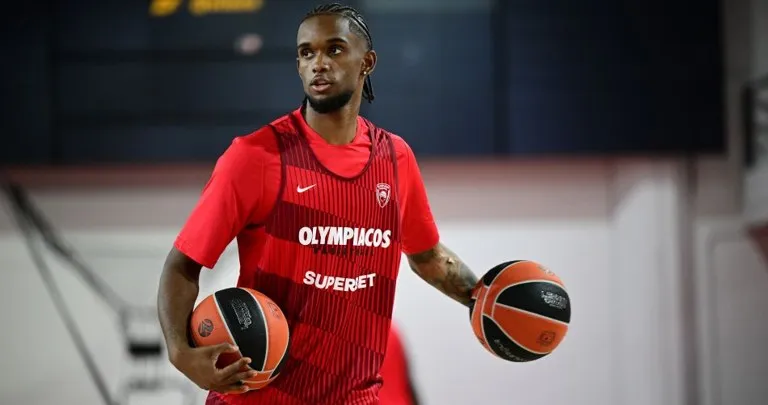 Lesión de Jean Montero: el escolta dominicano del Olympiacos, con el uniforme de entrenamiento del club griego y dos balones en las manos
