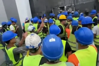Obreros con cascos y chalecos de seguridad concentrados en la obra del aeropuerto de Maiquetía