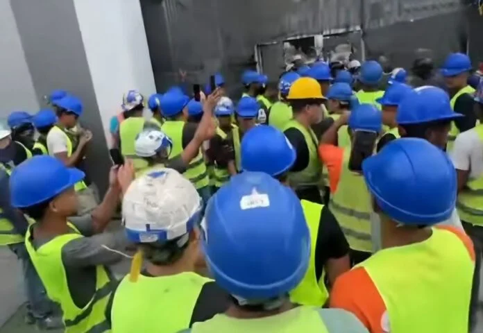 Obreros con cascos y chalecos de seguridad concentrados en la obra del aeropuerto de Maiquetía