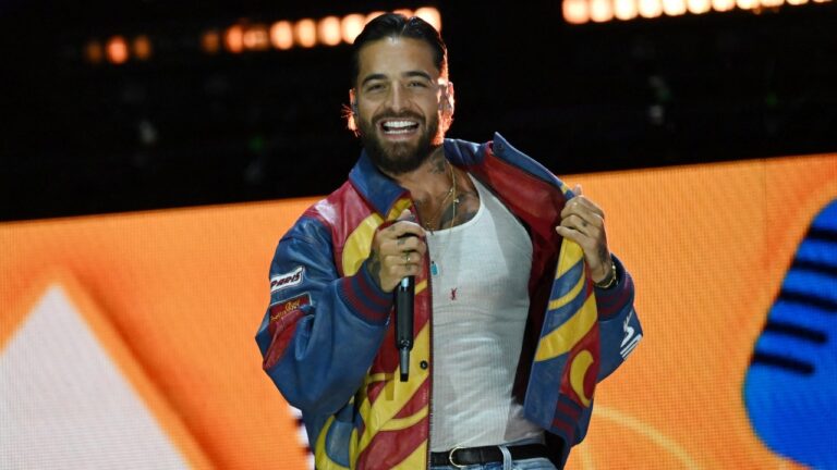 Maluma trastorno alimenticio: el cantante colombiano sonríe sobre un escenario con micrófono en mano