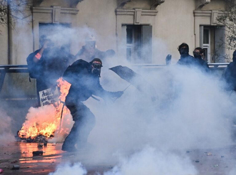 Manifestante en Francia entre humo y fuego durante las protestas de este sábado en las que un joven perdió una mano en Saint-Étienne