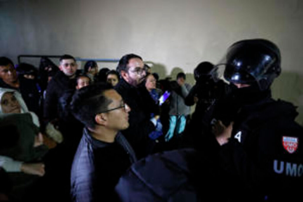 Masacres en cárceles de Ecuador: un agente de la UMO de la Policía frente a familiares de reclusos en un centro penitenciario ecuatoriano